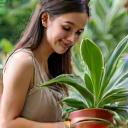 Una donna che sorride mentre annaffia una pianta rara.