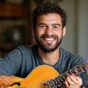 Un uomo sorridente che tiene in braccio la sua chitarra vintage.