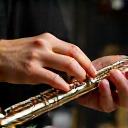 Mani che lucidano con cura un ottavino antico.